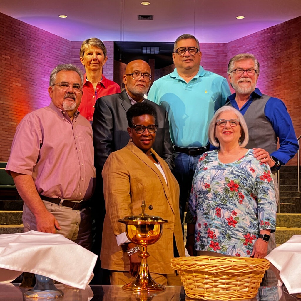 Seven adults posing near church communion table
